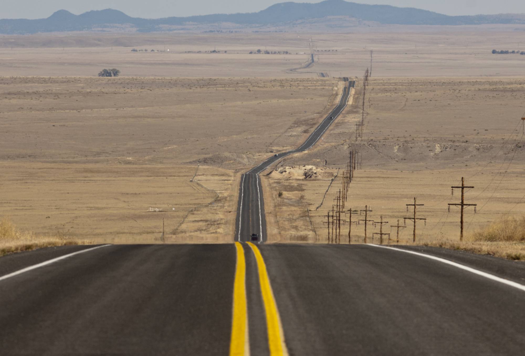 A picture of a road with mountains in the distance