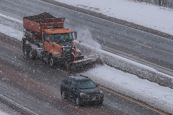 A photo of a truck plowing the roads