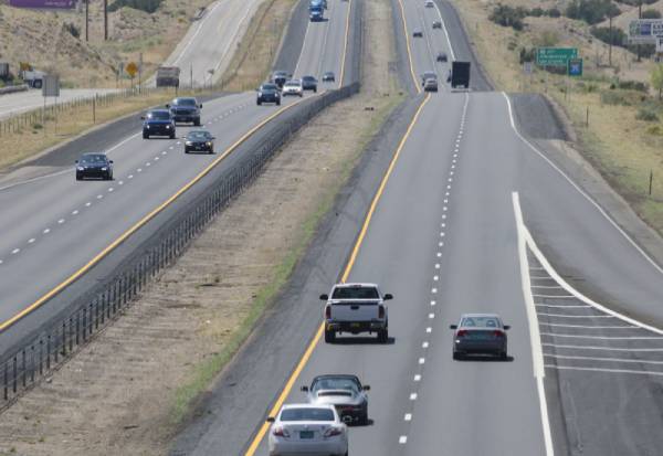 A photo of several cars driving on the freeway