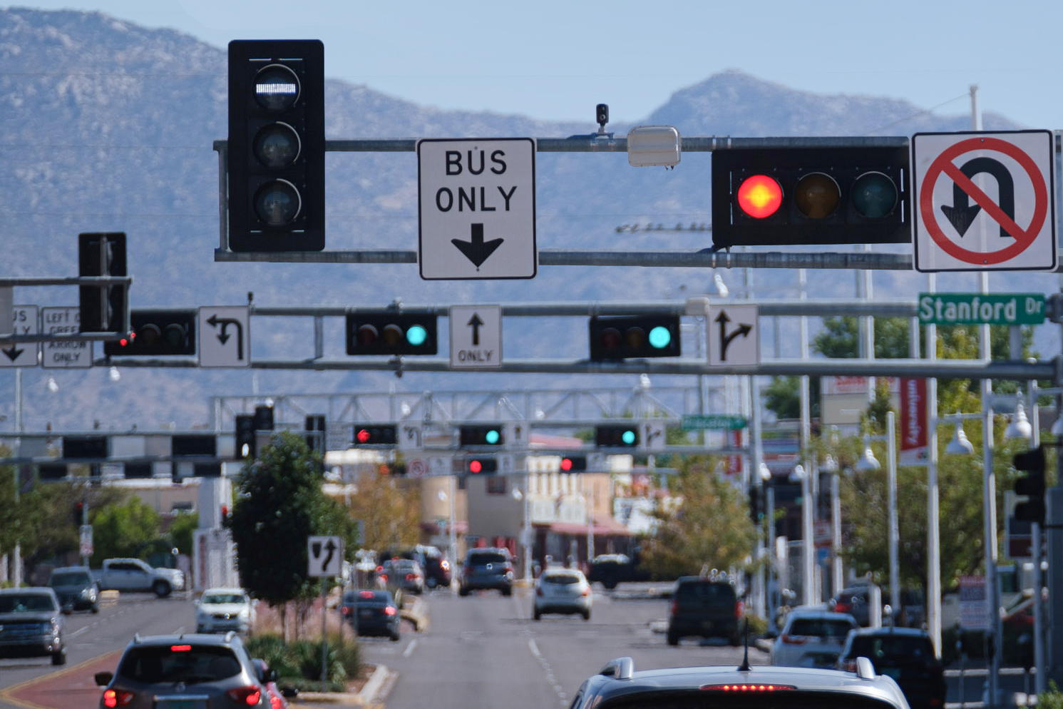 A photo of traffic lights and a bus only sign